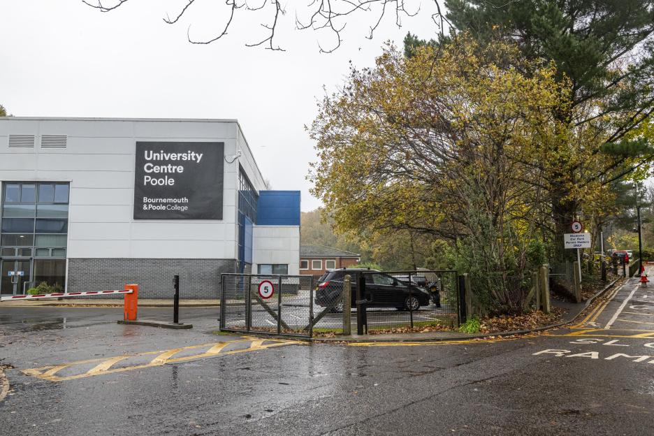 The University Centre Poole at Bournemouth & Poole College, with an orange barrier arm and "5" speed limit signs at a car park entrance.