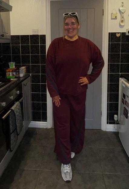 Becki Jones in a maroon tracksuit in her kitchen.