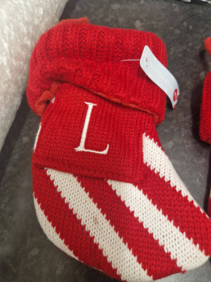 Red and white striped knitted slipper with an embroidered L.