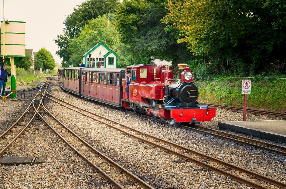 A passenger train arriving at Aylsham station on the Bure Valley Railway in Norfolk UK
