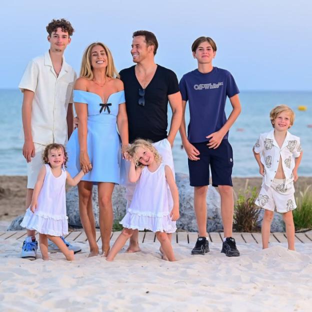 A family of six on a beach, with parents and four children.