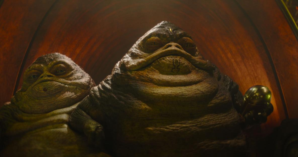 Two Hutts, one larger than the other, looking directly at the camera.