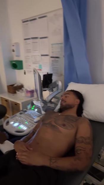 A man with tattoos on his chest and arms undergoes a medical examination with an ultrasound machine.