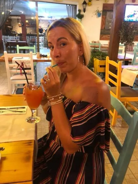 Kandice Barber sipping a drink at a restaurant.