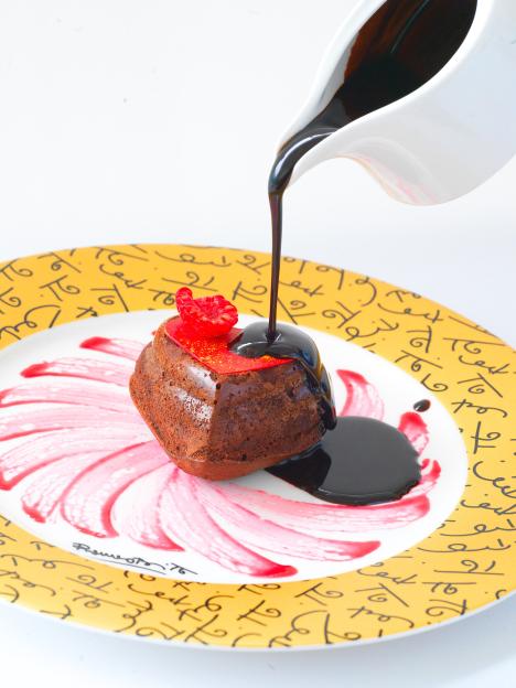 Chocolate lava cake with raspberry and chocolate sauce.