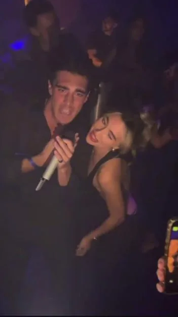 Love Island winner Lorenzo holds a microphone while standing close to his ex Yasmin at a party.