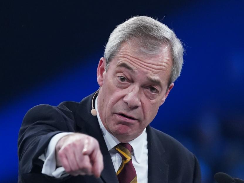 Reform UK leader Nigel Farage speaks and points to the audience at a rally.