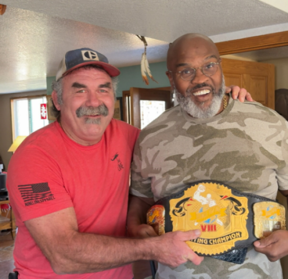 Frye and Goodridge holding a wrestling championship belt.