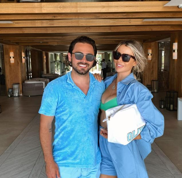 A man and a woman posing together in a hotel lobby.