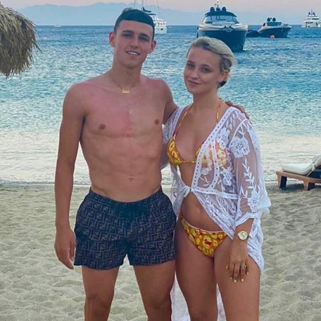 Phil Foden and Rebecca Cooke on a beach.