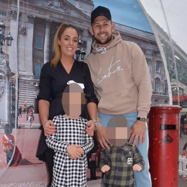 Liam Canning posing with his wife and two children in front of Buckingham Palace backdrop.