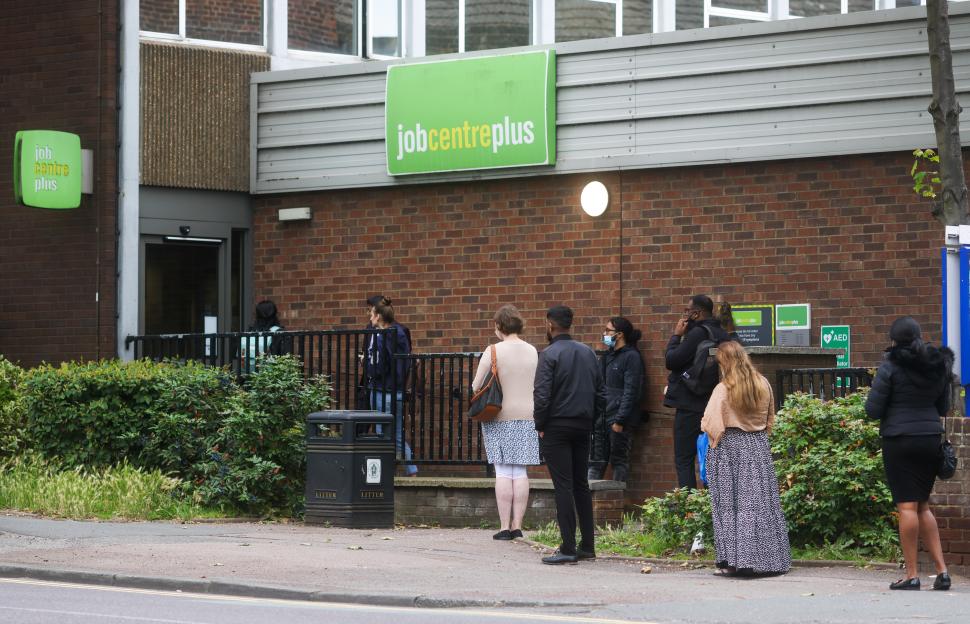People queue outside a Jobcentre Plus in Romford, UK.