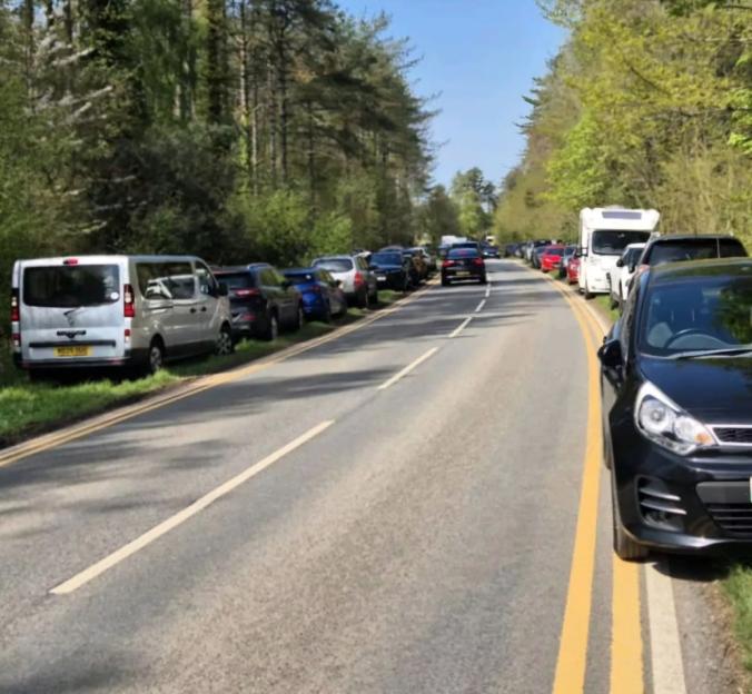 Kerb parking on double yellow lines on the A4080 at Newborough Forest, highlighting traffic chaos.