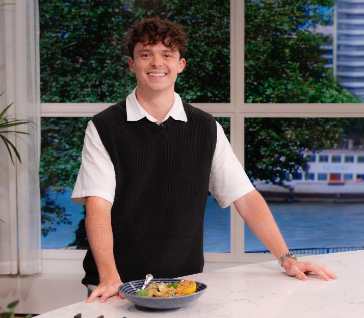 Sam Holland smiles as he presents a dish on the set of 'This Morning' TV show.