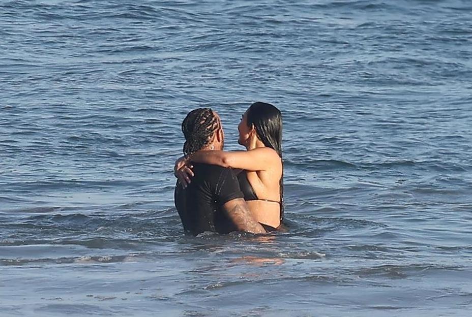 Kim Kardashian and Lewis Hamilton embracing in the ocean.