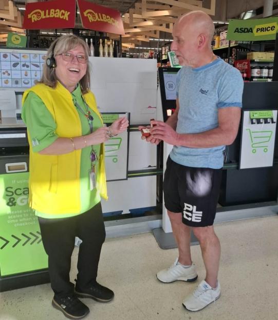 A man proposing to a woman at a self-checkout in a grocery store.