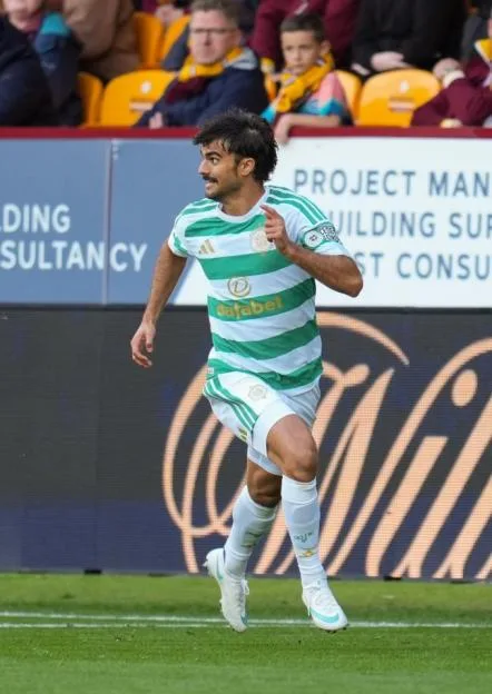 A Celtic player in a green and white hooped kit runs on the pitch during a match against Motherwell at Fir Park.