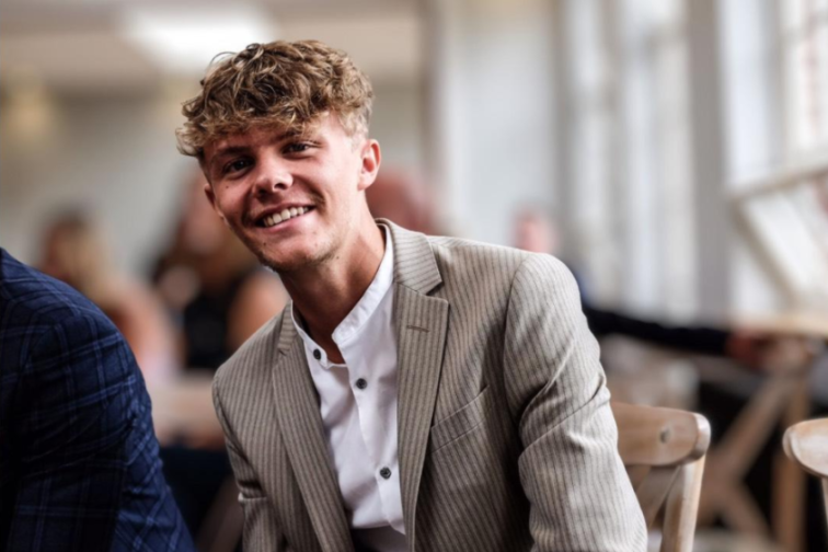 Luke Haffield, a young man with curly hair, smiling.