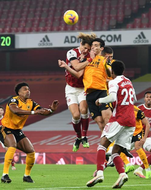 David Luiz of Arsenal and Raul Jimenez of Wolves collide while heading a soccer ball.