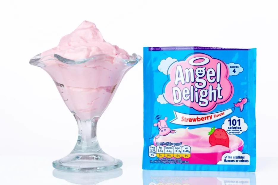 A glass dish filled with strawberry Angel Delight next to a packet of the dessert mix.