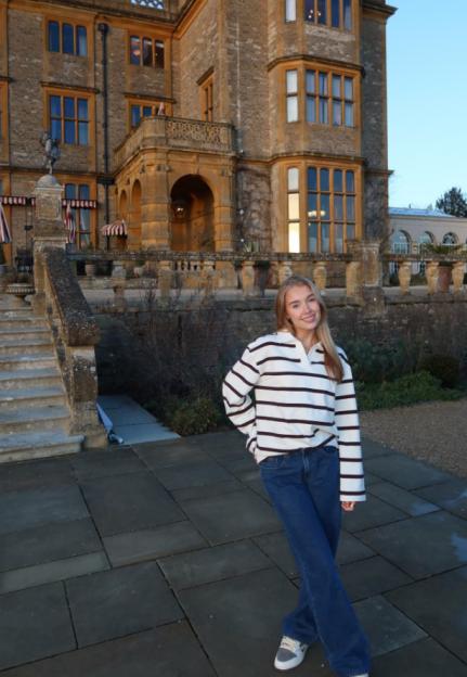 Hattie Dynevor standing in front of a large stone building.