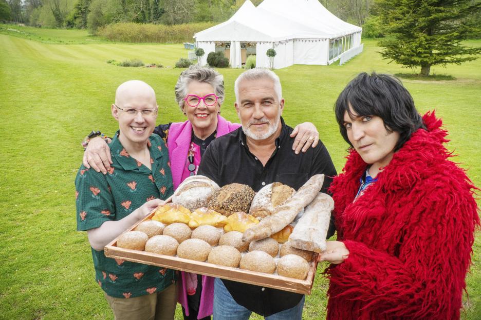 Matt, Paul, Prue, and Noel holding a tray of baked goods.