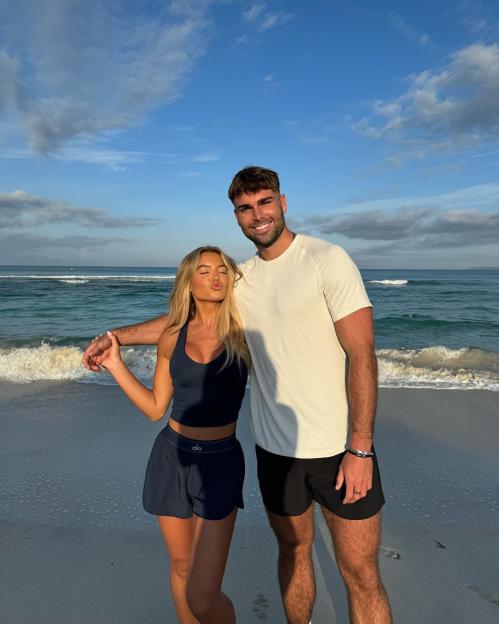 Molly Smith and Tom Clare posing on a beach.