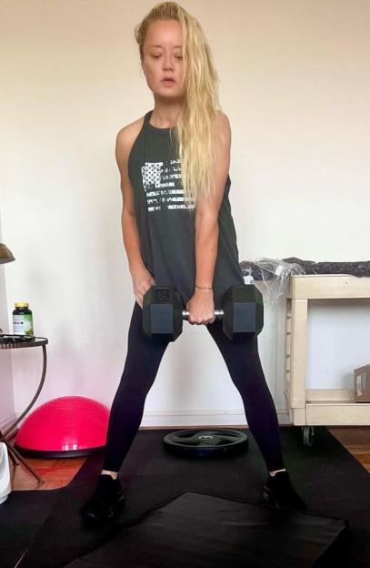 Lucy Davis working out at home, holding a dumbbell.
