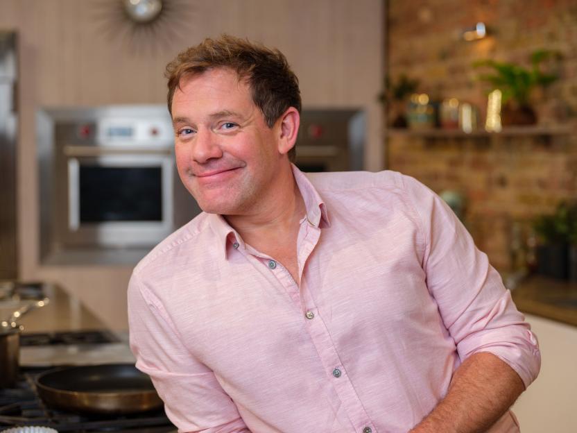 TV host and chef Matt Tebbutt smiling in a kitchen.
