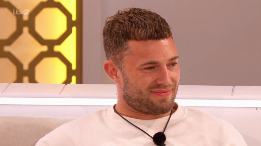 A man in a white sweatshirt smiling.