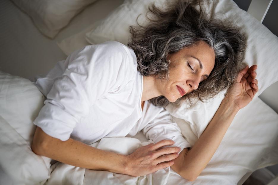 Mature woman sleeping in bed.