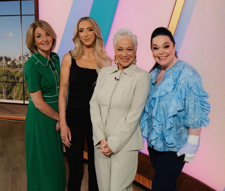 Kaye Adams, GK Barry, Denise Welch, and Lisa Riley posing on a television set.