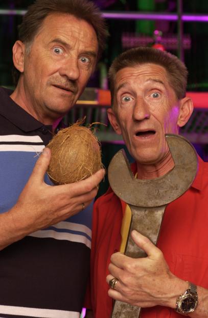 Barry and Paul Chuckle looking surprised, holding a coconut and a large wrench.