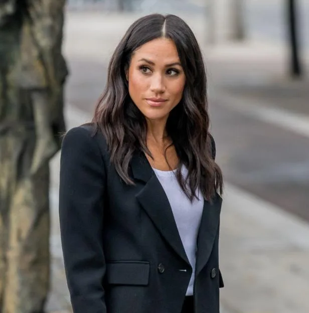 Meghan Markle, Duchess of Sussex, wearing a black blazer and white top.