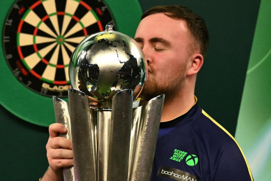 Man kissing the World Darts Championship trophy.