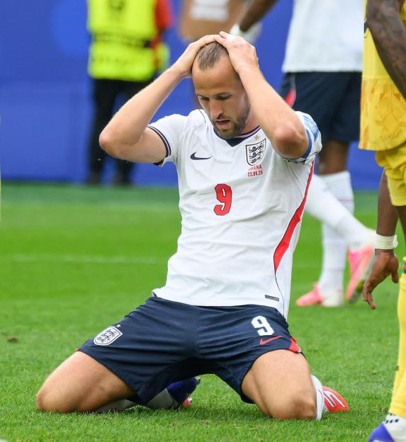 Harry Kane on his knees, hands on his head, after missing a late chance in the World Cup match between England and Ghana.