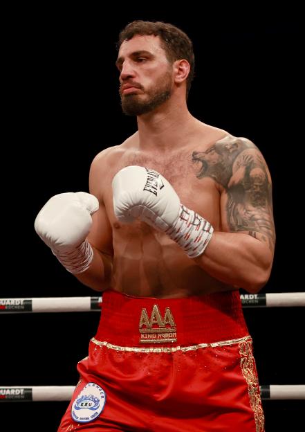 Agron Smakici in red shorts and white gloves during his EBU European Heavyweight Championship fight.