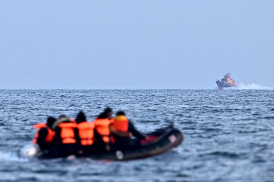 A lifeboat approaches an inflatable boat carrying migrants across the English Channel.