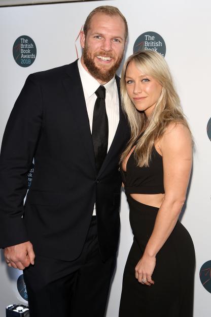 Man in a suit and woman in a black dress posing at the British Book Awards 2018.