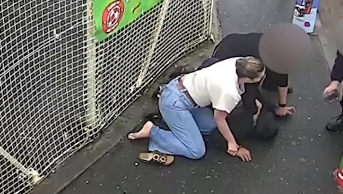 Nicholas Noble being restrained by a staff member and PC Alice O'Brien at a petrol station.