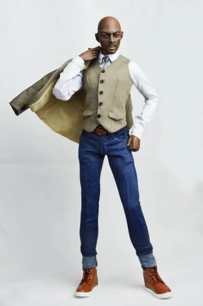 A detailed action figure of Idris Elba wearing a vest, blue jeans, and holding a jacket over his shoulder.