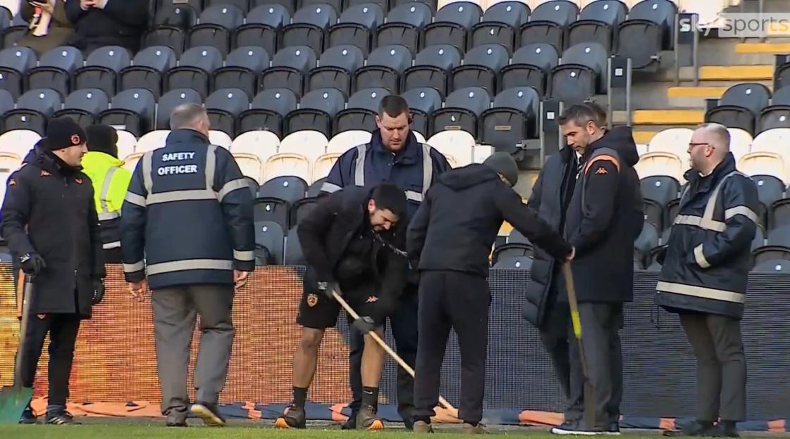 Groundsmen melting ice on the field at MKM Stadium.