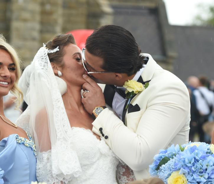 The bride, Venezuela Fury, and groom, Noah Price, kissing at their wedding.