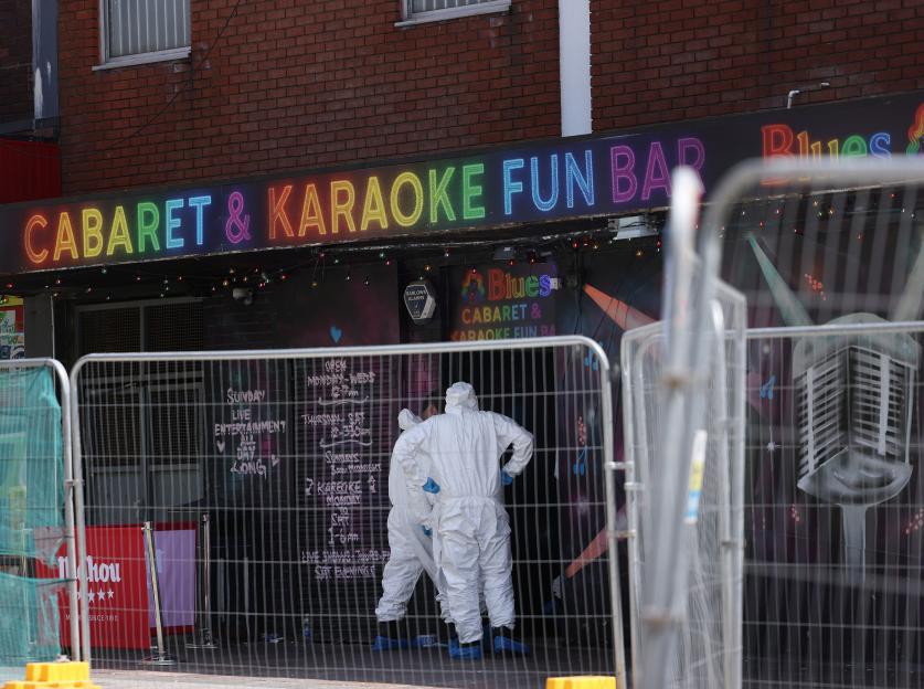 Police forensic investigators at the scene of a murder investigation outside the "Cabaret & Karaoke Fun Bar".