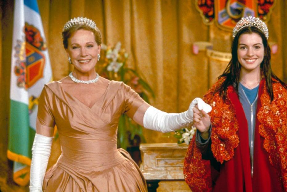 Julie Andrews as Queen Clarisse and Anne Hathaway as Mia Thermopolis, holding hands while dressed in formal attire.