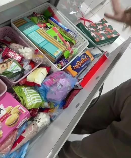 A partially open drawer filled with various snacks and treats.