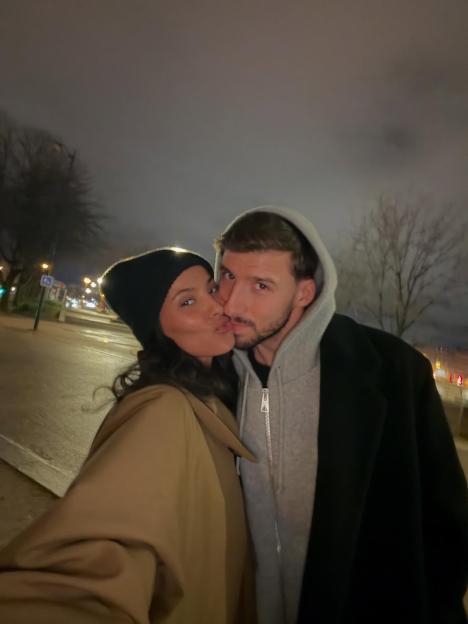 Maya Jama and Ruben Dias kissing at night.