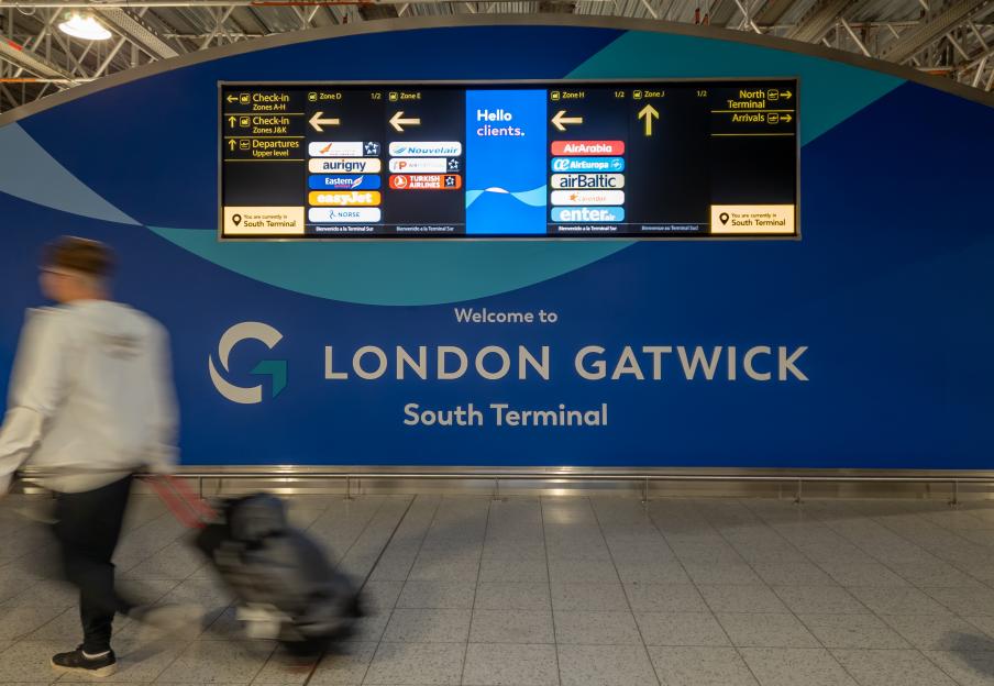 A welcome sign at London Gatwick South Terminal with flight information.