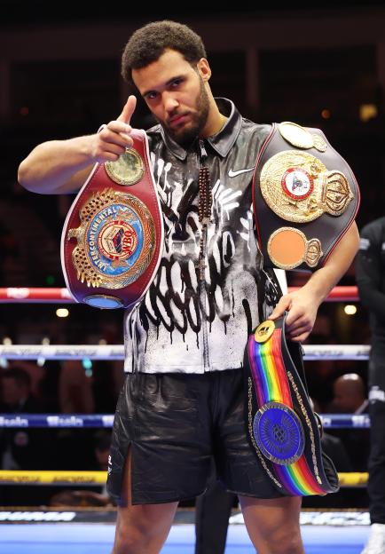 Moses Itauma holding up boxing belts after his WBO Inter-Continental Heavyweight title fight.