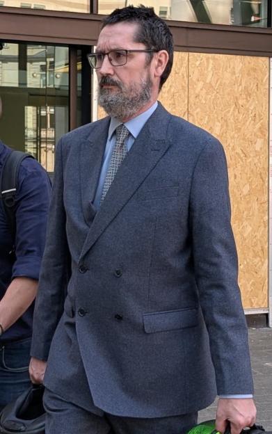 PC Christopher Johnson, accused of causing death by dangerous driving, stands outside a building.